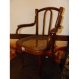 A VINTAGE THONET BENTWOOD CHILD'S ARMCHAIR WITH CANE SEAT, STAMPED THONET.