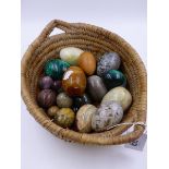 A BASKET OF HARDSTONE AND SPECIMEN MINERAL EGGS OF VARIOUS SIZES TO INCLUDE MALACHITE, MARBLE AND