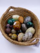 A BASKET OF HARDSTONE AND SPECIMEN MINERAL EGGS OF VARIOUS SIZES TO INCLUDE MALACHITE, MARBLE AND