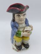 A STAFFORDSHIRE TOBY JUG WITH BLUE COAT AND FOAMING JUG. 25cms HGIH.