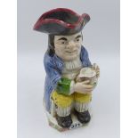 A STAFFORDSHIRE TOBY JUG WITH BLUE COAT AND FOAMING JUG. 25cms HGIH.