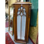 A PAIR OF CARVED AND INLAID OAK ART DECO TALL CABINETS WITH SHAPED STEPPED TOPS ABOVE GLAZED DOORS