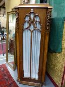 A PAIR OF CARVED AND INLAID OAK ART DECO TALL CABINETS WITH SHAPED STEPPED TOPS ABOVE GLAZED DOORS