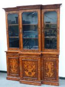 A CONTINENTAL BURL WALNUT MARQUETRY INLAID BREAKFRONT BOOKCASE WITH MOULDED CORNICE ABOVE THREE