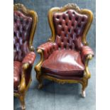 A PAIR OF CARVED ARMCHAIRS IN THE VICTORIAN STYLE COVERED IN CLARET STUDDED LEATHER.