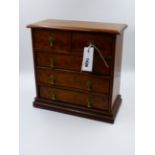 A MINIATURE YEW WOOD CHEST OF DRAWERS OF TWO SHORT DRAWERS OVER THREE LONG DRAWERS. H.30cms.