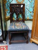 AN ANTIQUE CARVED WALNUT GOTHIC REVIVAL HALL CHAIR WITH PIERCED TRACERY BACK AND FLORAL