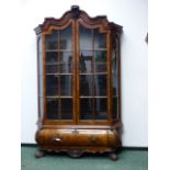 AN ANTIQUE DUTCH CARVED WALNUT DISPLAY CABINET IN THE 18th.C.STYLE. SHAPED CORNICE ABOVE TWO
