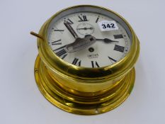 A BRASS CASED SMITHS BULKHEAD TYPE CLOCK WITH PAINTED ROMAN NUMERAL DIAL.