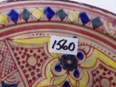 AN INTERESTING EASTERN POTTERY FOOTED DISH WITH STYLISED POLYCHROME DECORATION. DIA. 28cms.