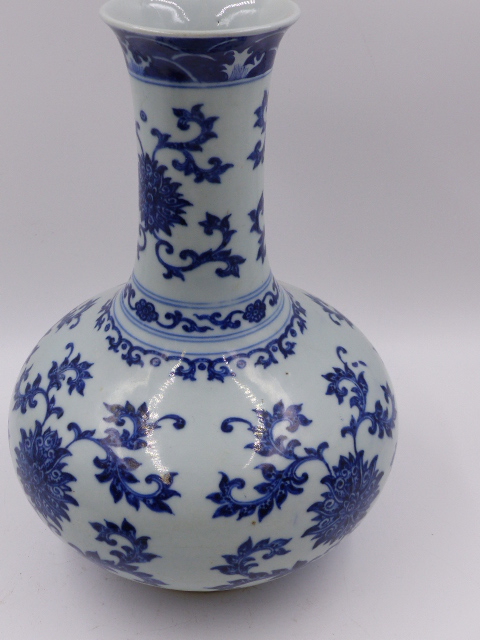 A CHINESE BLUE AND WHITE BOTTLE FORM VASE WITH FLOWER HEAD AND SCROLLING FOLIATE DECORATION. H.27. - Image 4 of 6
