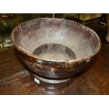 AN EARLY LARGE TURNED WOODEN BOWL WITH STEPPED FOOT AND METAL BOUND RIM. D.37, H.25cms.