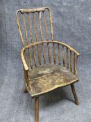 AN ANTIQUE COUNTRY MADE RUSTIC WINDSOR ARMCHAIR WITH UNUSUAL COMB BACK AND SHAPED SEAT.