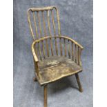 AN ANTIQUE COUNTRY MADE RUSTIC WINDSOR ARMCHAIR WITH UNUSUAL COMB BACK AND SHAPED SEAT.