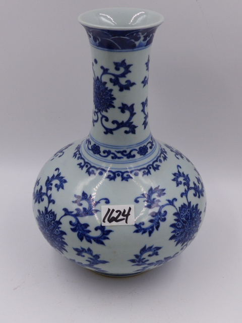 A CHINESE BLUE AND WHITE BOTTLE FORM VASE WITH FLOWER HEAD AND SCROLLING FOLIATE DECORATION. H.27.