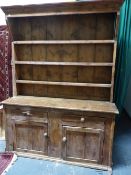 AN ANTIQUE COUNTRY PINE DRESSER WITH PLATE RACK ABOVE TWO DRAWERS AND TWO PANELLED DOORS, POSSIBLY