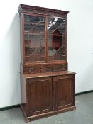 A LATE GEORGIAN MAHOGANY BOOKCASE CABINET WITH ASTRAGAL GLAZED DOORS OVER TWO DEEP DRAWERS AND