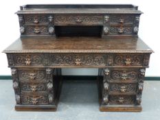 A LARGE LATE 19th.C.CARVED OAK TWIN PEDESTAL DESK WITH RAISED FIVE DRAWER SUPER STRUCTURE OVER. W.