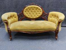 A VICTORIAN CARVED WALNUT MEDALLION BACK SETTEE WITH SHAPED BUTTONED FORM AND SCROLL LEGS. W.