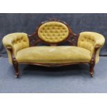 A VICTORIAN CARVED WALNUT MEDALLION BACK SETTEE WITH SHAPED BUTTONED FORM AND SCROLL LEGS. W.