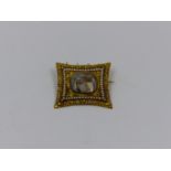 A GEORGE III GOLD AND SPEED PEARL MEMORIAL BROOCH DESIGNED AS AN OVAL SHAPED SEPIA PANEL DEPICTING A