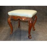 A CARVED WALNUT LOUIS XV STOOL WITH SHAPED SEAT, MOULDED SCROLL DECORATED FRAME AND CABRIOLE LEGS