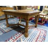 AN EARLY 20th.C. PALE OAK DRAW LEAF DINING TABLE WITH RING TURNED LEGS JOINED BY SHAPED CROSS