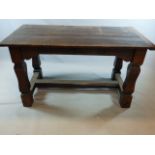 A CARVED OAK SMALL REFECTORY TABLE, PLANK TOP WITH BREADBOARD ENDS AND SQUARED LEGS JOINED BY MEDIAL