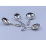 THREE SILVER HALLMARKED AND ONE WHITE METAL CADDY SPOONS OF VARIOUS DATES AND STYLES TO INCLUDE A