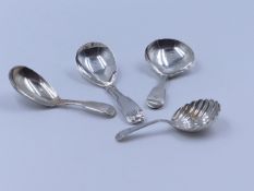 THREE SILVER HALLMARKED AND ONE WHITE METAL CADDY SPOONS OF VARIOUS DATES AND STYLES TO INCLUDE A