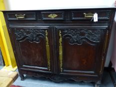 AN ANTIQUE CARVED OAK FRENCH PROVINCIAL CABINET WITH THREE FRIEZE DRAWERS ABOVE PANELLED TWO DOOR