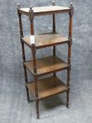 A LATE REGENCY MAHOGANY FOUR TIER WHAT NOT WITH TURNED SUPPORTS AND BRASS CASTORS. H.130cms, W.