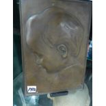 AN EARLY 20th.C. BRONZE PORTRAIT PLAQUE OF A CHILD INITIALLED D.B. 24.5 x 18cms.