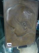 AN EARLY 20th.C. BRONZE PORTRAIT PLAQUE OF A CHILD INITIALLED D.B. 24.5 x 18cms.