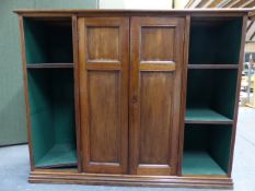 AN EDWARDIAN WALNUT BOOKCASE./CABINET WITH TWO CENTRAL PANELLED DOORS ENCLOSING SHELVES FLANKED BY