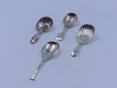 THREE SILVER HALLMARKED AND ONE WHITE METAL CADDY SPOONS OF VARIOUS STYLES AND DATES TO INCLUDE AN