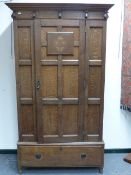 AN INLAID EDWARDAIN PANEL DOOR WARDROBE IN THE ARTS AND CRAFTS STYLE WITH SINGLE DRAWER TO BASE. H.