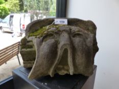 AN EARLY CARVED STONE ARCHITECTURAL ELEMENT OF A GROTESQUE MASK. H.28, W.46cms.