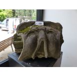 AN EARLY CARVED STONE ARCHITECTURAL ELEMENT OF A GROTESQUE MASK. H.28, W.46cms.