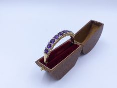 A 9ct. AMETHYST AND OPAL HINGED BANGLE WITH FIGURE OF EIGHT SAFETY CHAIN. HALLMARKED LONDON, DATED