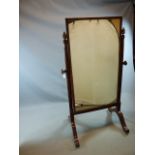 A CARVED MAHOGANY WILLIAM IV CHEVAL MIRROR WITH FLUTED COLUMN SUPPORTS SURMOUNTED BY ACORN