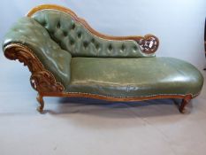 A VICTORIAN CARVED WALNUT CHAISE COVERED IN STUDDED OLIVE GREEN LEATHER ON SHORT CABRIOLE LEGS. W.