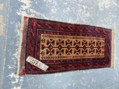 AN ANTIQUE BELOUCH RUG WITH FLAT WOVEN ENDS. 104 x 48cms.