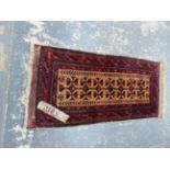 AN ANTIQUE BELOUCH RUG WITH FLAT WOVEN ENDS. 104 x 48cms.