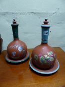 A NEAR PAIR OF TERRACOTTA LIDDED BOTTLE VASES WITH STAND DISHES DECORATED WITH CHINOISERIE SCENES.