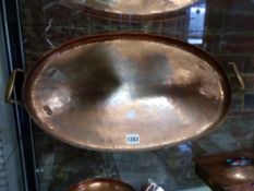 A HUGH WALLIS ARTS AND CRAFTS COPPER OVAL TWIN HANDLED TRAY WITH GADROON RIM. W.62cms.