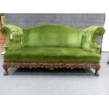 A CARVED WALNUT CAMEL BACK SETTEE IN THE IRISH GEORGIAN TASTE WITH BUTTONED ROLL OVER ARMS,