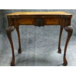 AN ANTIQUE AND LATER CARVED AND INLAID WALNUT EARLY GEORGIAN STYLE GAMES TABLE WITH SHAPED TOP AND