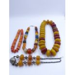 FOUR STRANDS OF NORTH AFRICAN TRIBAL BEAD NECKLACES.