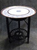 AN EBONISED AESTHETIC STAND WITH ASSOCIATED ROYAL WORCESTER BLUE AND WHITE CIRCULAR TOP. D.62cms.